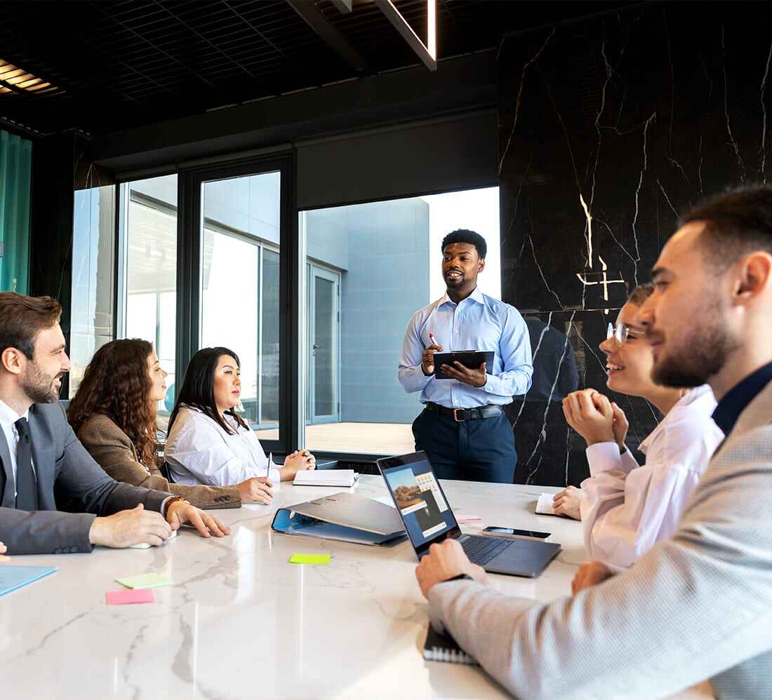 Business meeting with presenter discussing digital marketing strategy at conference table.