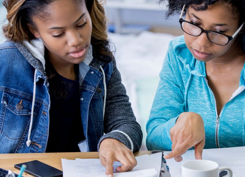 Team collaborating on financial documents at home, discussing budgeting and financial planning strategies